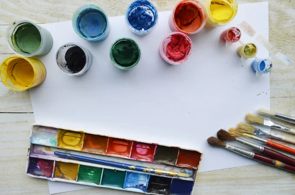 Set of brushes and paints on wooden table — Stock Photo, Image