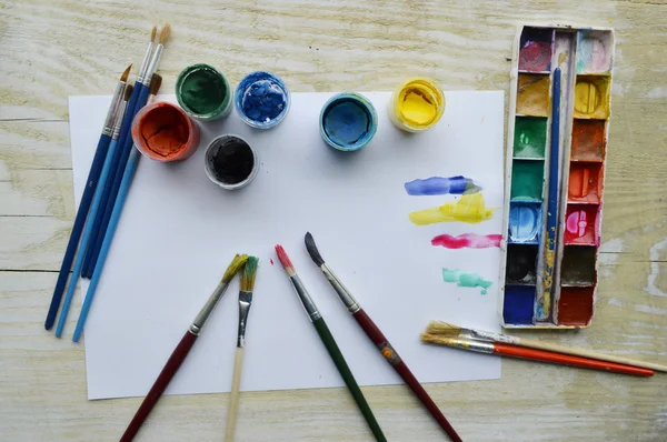 Set de pinceles y pinturas sobre mesa de madera —  Fotos de Stock