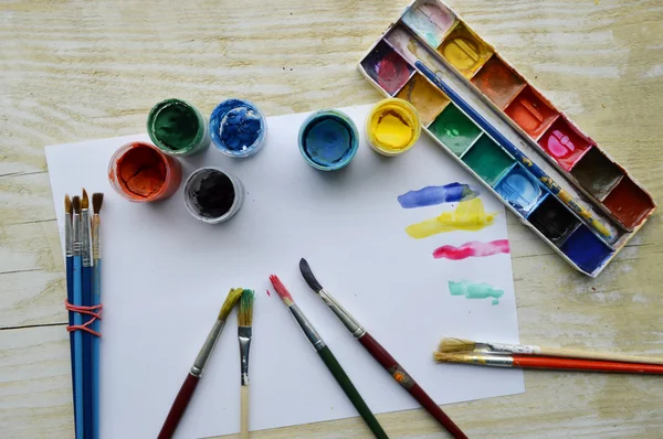 Set of brushes and paints on wooden table — Stock Photo, Image