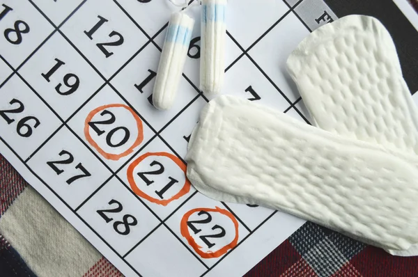 女人卫生防护，关闭 up.menstruation 日历与棉花卫生棉条，橙色格柏，卫生护垫红色背景上 — 图库照片
