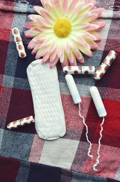 Woman hygiene protection, close-up.menstruation calendar with cotton tampons,orange Gerber,Sanitary pads on a red background — Stock Photo, Image