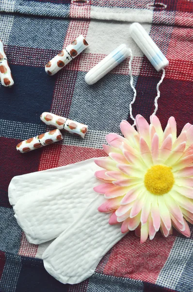 Kadın hijyen koruma, kırmızı bir arka plan üzerinde pamuk tampon, turuncu Gerber, sıhhi yastıkları ile yakın-up.menstruation takvimi — Stok fotoğraf