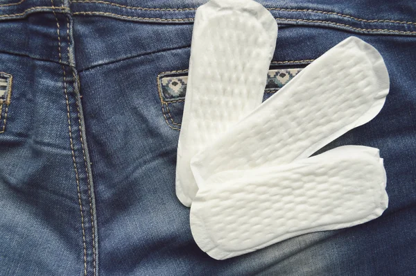 Proteção de higiene da mulher, close-up.menstruation calendário com tampões de algodão, laranja Gerber, Almofadas sanitárias em um fundo vermelho — Fotografia de Stock