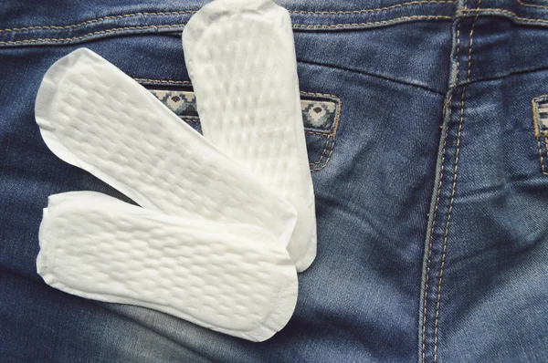 Žena hygienické ochrany, close-up.menstruation kalendář s bavlněné tampony, oranžová Gerbera, hygienické podložky na červeném pozadí — Stock fotografie