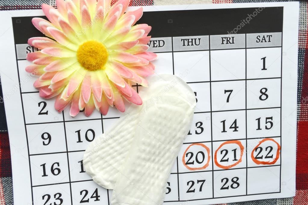 Woman hygiene protection, close-up.menstruation calendar with cotton tampons,orange Gerber,Sanitary pads on a red background