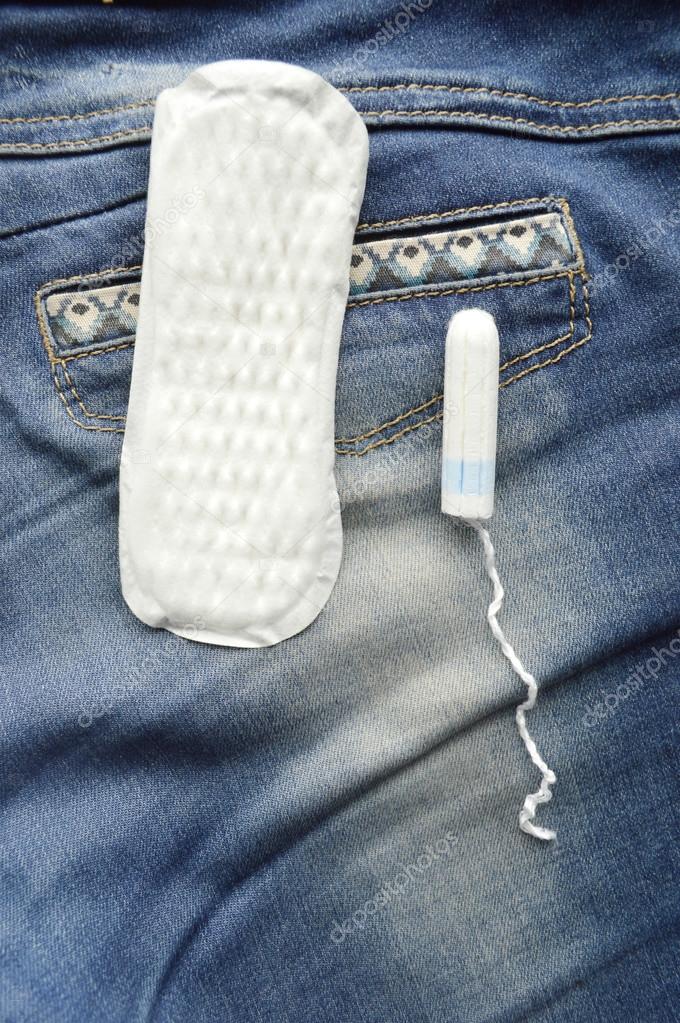 Woman hygiene protection, close-up.menstruation calendar with cotton tampons,orange Gerber,Sanitary pads on a red background