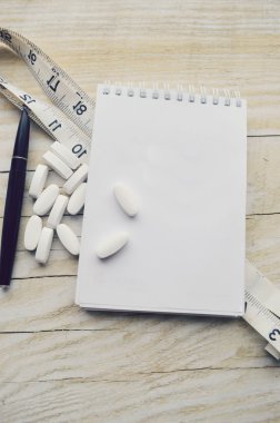 Ölçüm bandı, hap ve not defteri