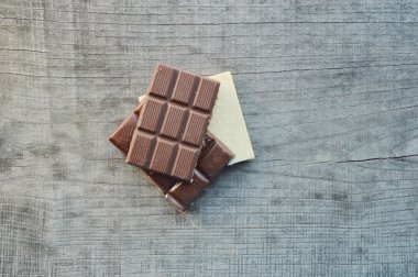 Bar çikolata, kahve çekirdekleri, fındık, ceviz, tarçın, kişniş, baharat veiki bar, gofret, ahşap arka plan üzerinde farklı çikolata tatlılar