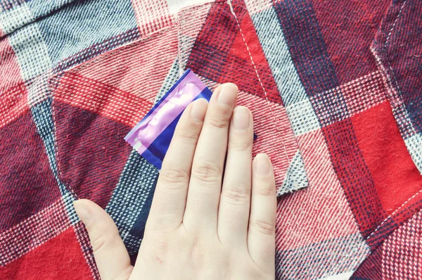 Woman hand on condom — Stock Photo, Image