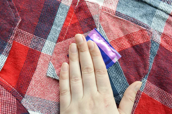 Woman hand on condom — Stock Photo, Image