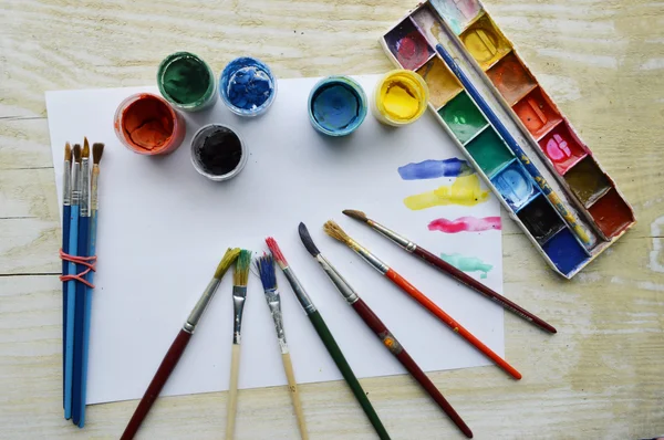 Brushes with paints and paper — Stock Photo, Image