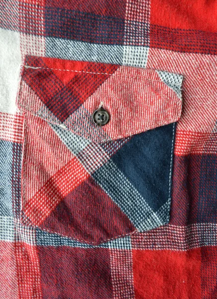 Detail of a red plaid button up style shirt.