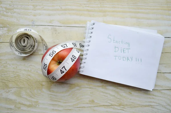 Cuaderno con cinta métrica y una manzana — Foto de Stock