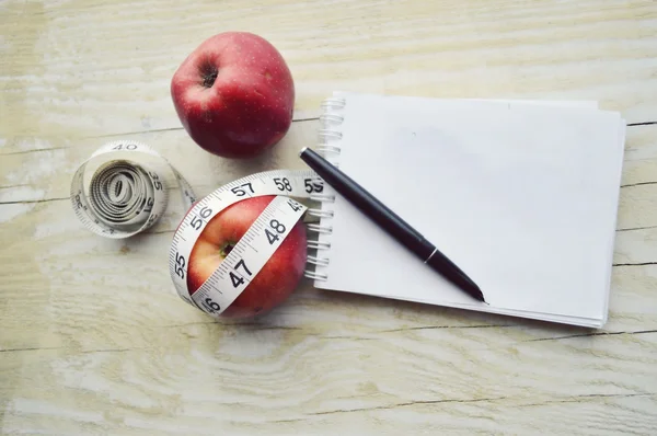 Carnet avec ruban à mesurer et deux pommes — Photo