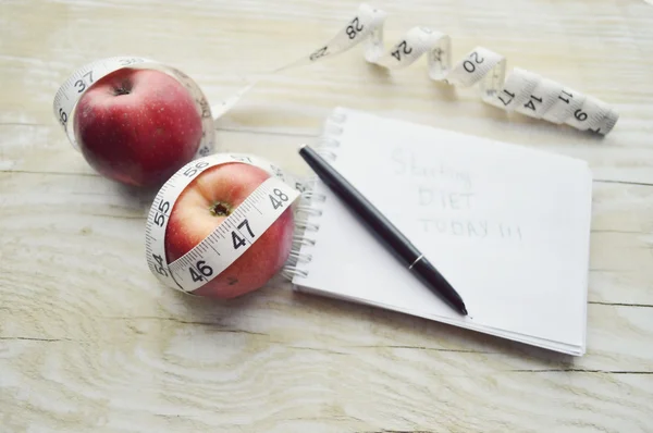 Carnet avec ruban à mesurer et deux pommes — Photo