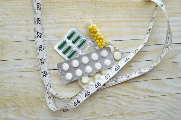 Measuring tape and pills — Stock Photo, Image