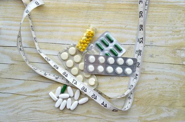 Measuring tape and pills — Stock Photo, Image
