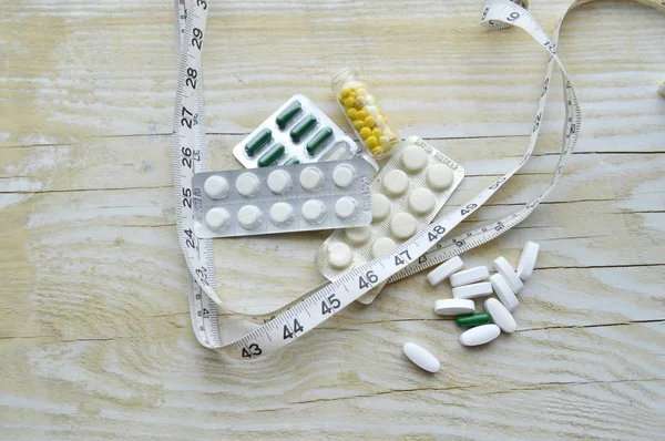 Measuring tape with pills — Stock Photo, Image