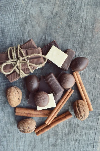 Barras de chocolate, doces, canela e nozes — Fotografia de Stock