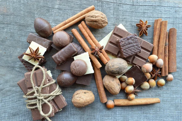Vários pedaços de chocolate e canela com nozes e anis — Fotografia de Stock