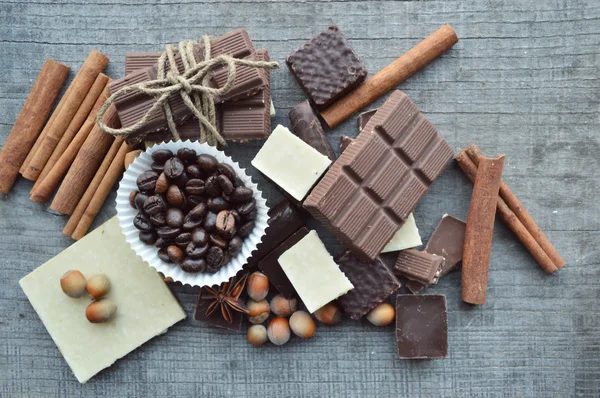 Bar av choklad, kaffebönor, hasselnötter, valnötter, kanel, koriander, kryddor .chocolate bar, barer godis, olika choklad godis på en trä background.big val av olika sötsaker — Stockfoto