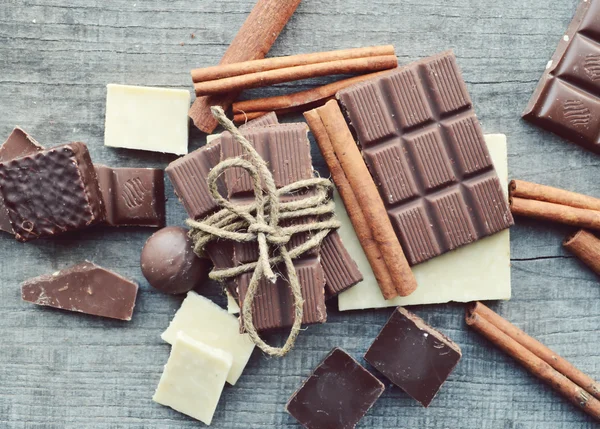 Vários pedaços de chocolate e canela e anis — Fotografia de Stock