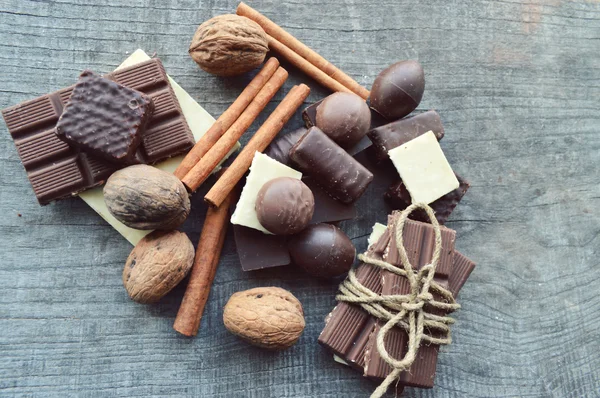 Vários pedaços de chocolate e nozes com canela — Fotografia de Stock