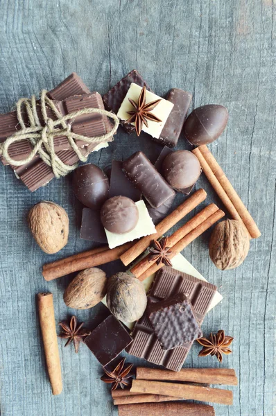 Vários pedaços de chocolate e nozes com canela e anis — Fotografia de Stock