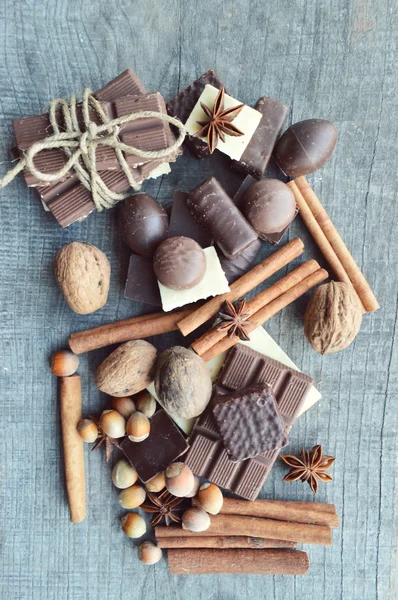Bár a csokoládé, szemes kávé, mogyoró, dió, fahéj, koriander, fűszerek .chocolate bár, csokit, egy fából készült background.big választás a különböző édességek a különböző csokoládé édességek — Stock Fotó