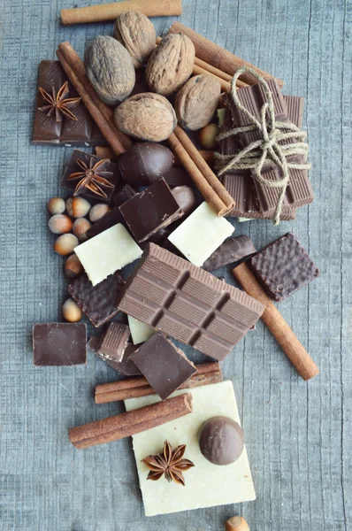 バーのチョコレート、コーヒー豆、ヘーゼル ナッツ、クルミ、シナモン、コリアンダー、スパイス .chocolate バー、キャンディ バーのさまざまなお菓子の木製 background.big 選択に別のチョコレート菓子 — ストック写真