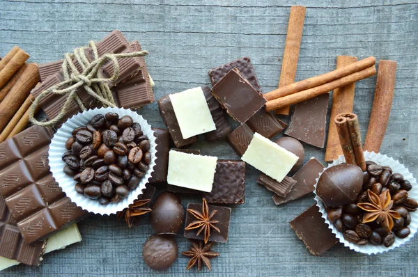 Bar av choklad, kaffebönor, hasselnötter, valnötter, kanel, koriander, kryddor .chocolate bar, barer godis, olika choklad godis på en trä background.big val av olika sötsaker — Stockfoto