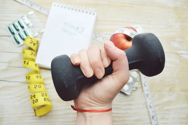 Woman hand with dumbell, pill, notes and measuring type — Stock Photo, Image