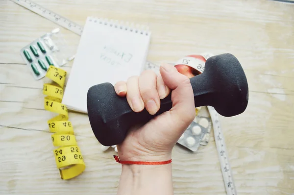 Woman hand with dumbell, pill, notes and measuring type — Stock Photo, Image