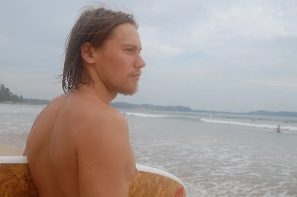 Surfista com sua prancha na água — Fotografia de Stock