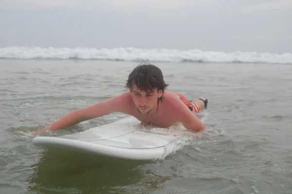 Surfista em sua prancha na água — Fotografia de Stock