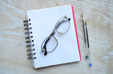 İki kalem ve gözlük ile dizüstü bilgisayar