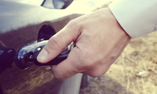 Mano masculina con llaves del coche abriendo la puerta del coche —  Fotos de Stock