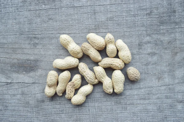 Nuts on rustic old wooden table — Stock Photo, Image