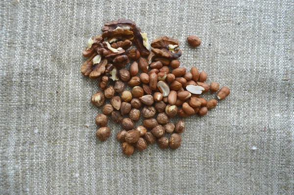 Nuts on rustic old wooden table — Stock Photo, Image