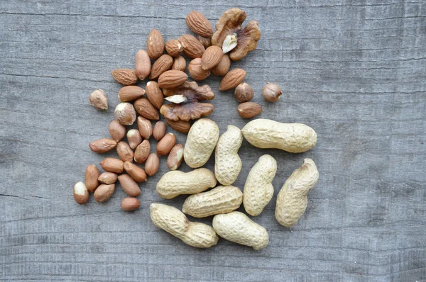 Nuts on rustic old wooden table — Stock Photo, Image