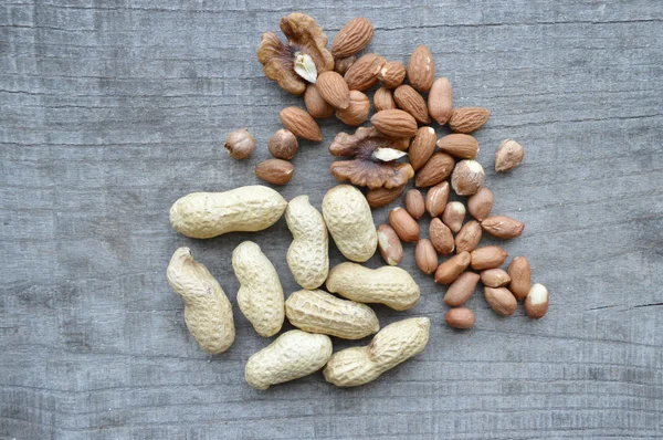 Nuts on rustic old wooden table — Stock Photo, Image