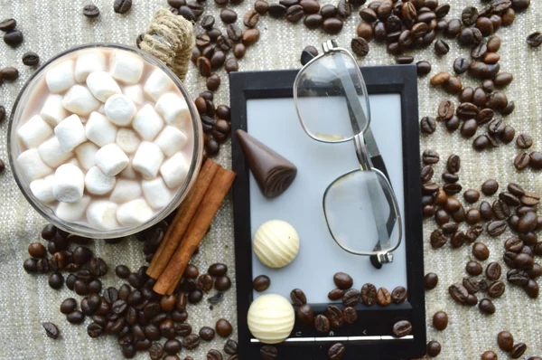 Marshmallows em tigela com Ebook e copos, doces e grãos de café — Fotografia de Stock