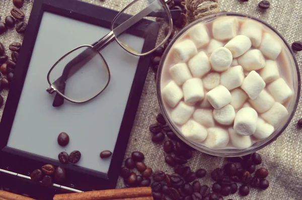 電子ブックやメガネ、キャンディーやコーヒー豆をボウルに入れてマシュマロ — ストック写真