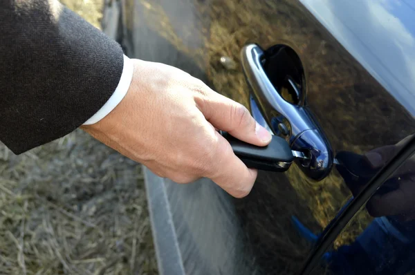 Male hand with car keys opening car door — Stock Photo, Image