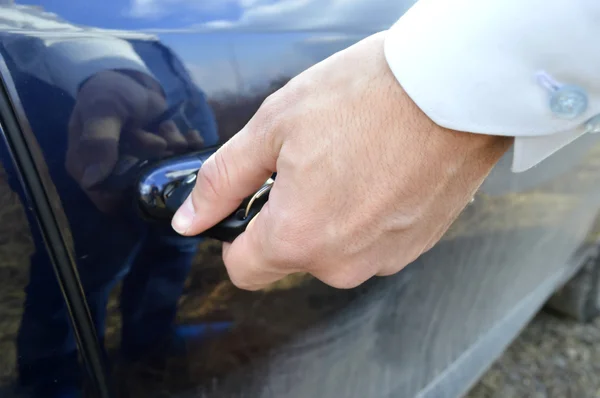 Mano masculina con llaves del coche abriendo la puerta del coche —  Fotos de Stock