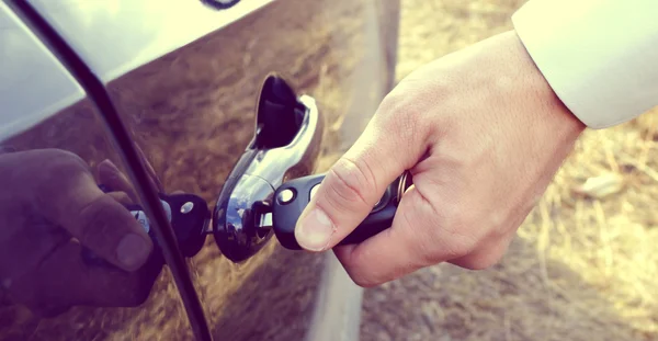 Мужская рука с ключами от машины, открывающая дверь машины — стоковое фото