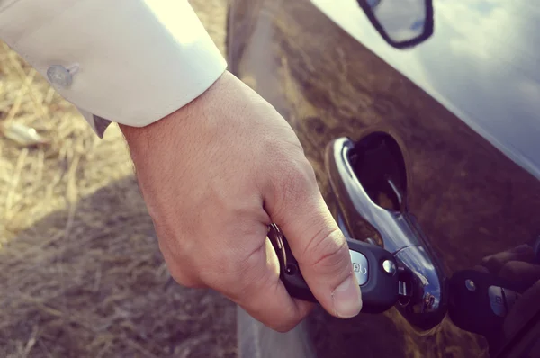 Мужская рука с ключами от машины, открывающая дверь машины — стоковое фото