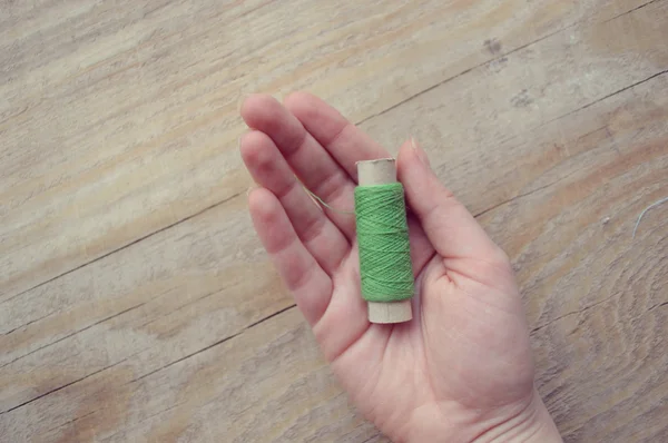 Hand holds the spool of thread — Stock Photo, Image