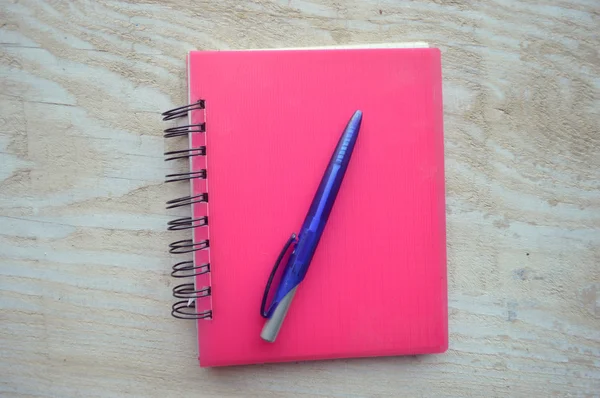 Caderno com uma caneta na mesa de madeira — Fotografia de Stock