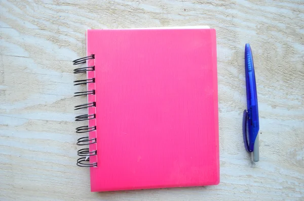 Caderno com uma caneta na mesa de madeira — Fotografia de Stock